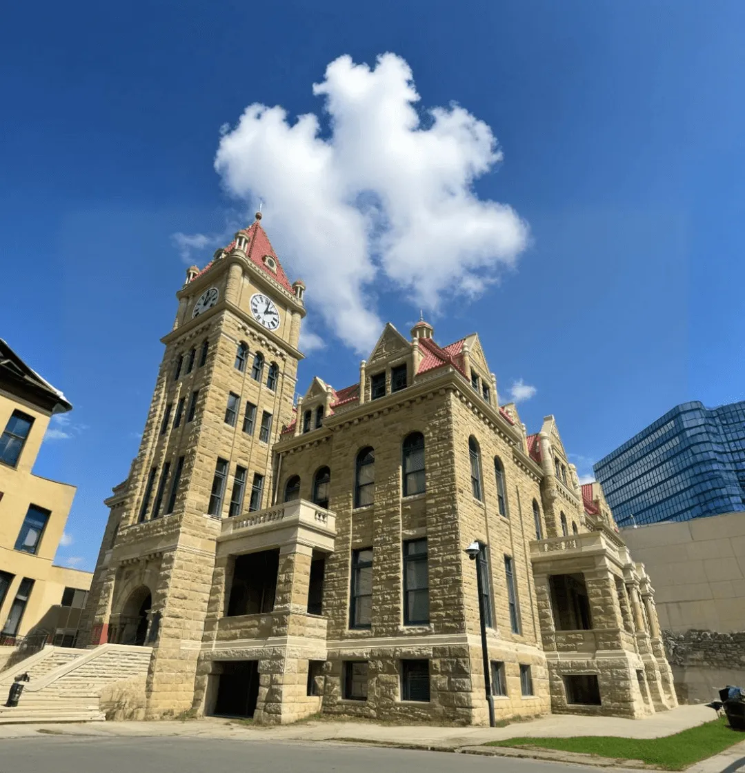 Historic sandstone city hall building with a clock tower.